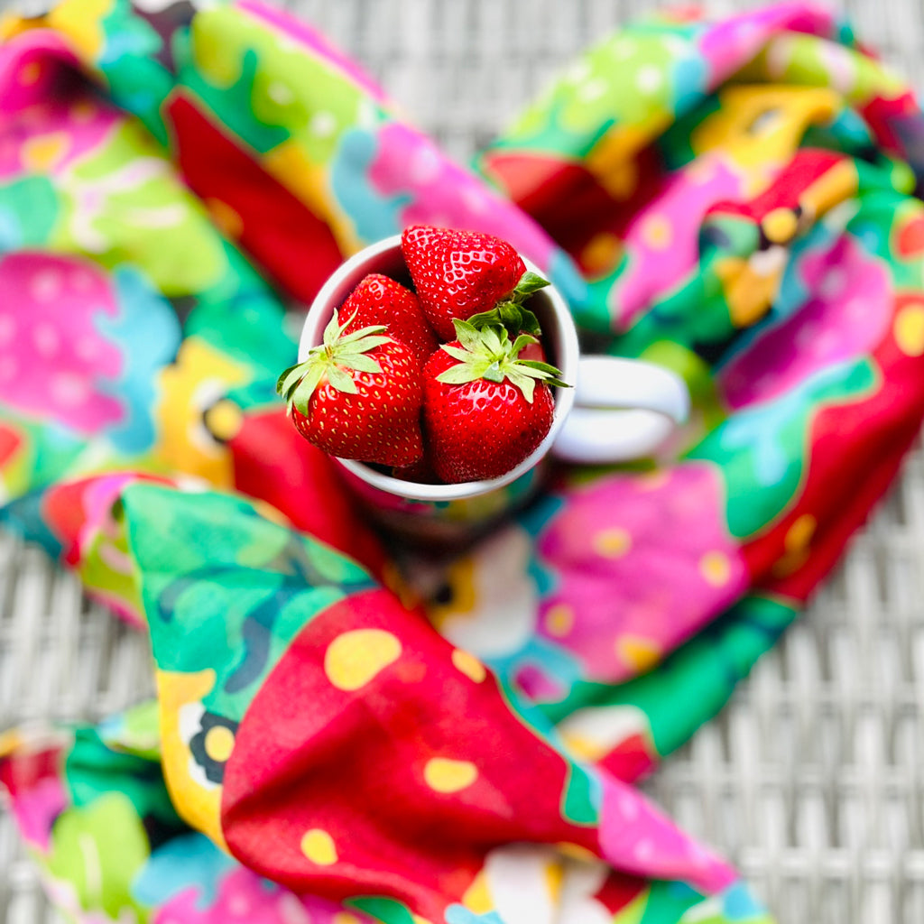 Colorful BERRYLEI scarf styled around a cup of fresh strawberries.
