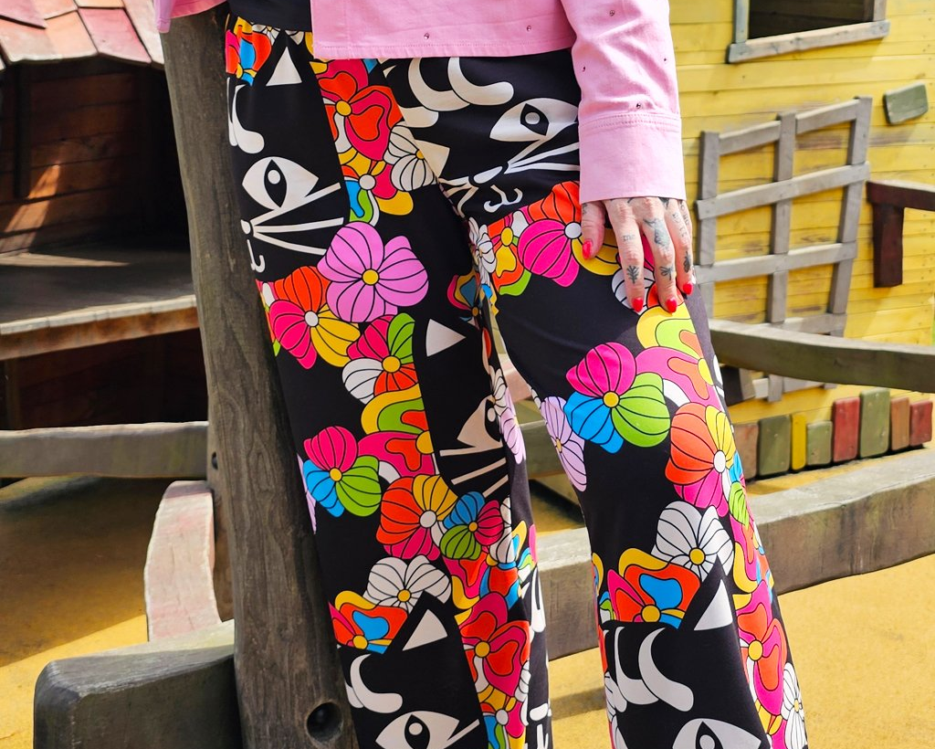 Colorful bottoms - wide-leg pants with bold floral and cat print, styled for everyday wear.